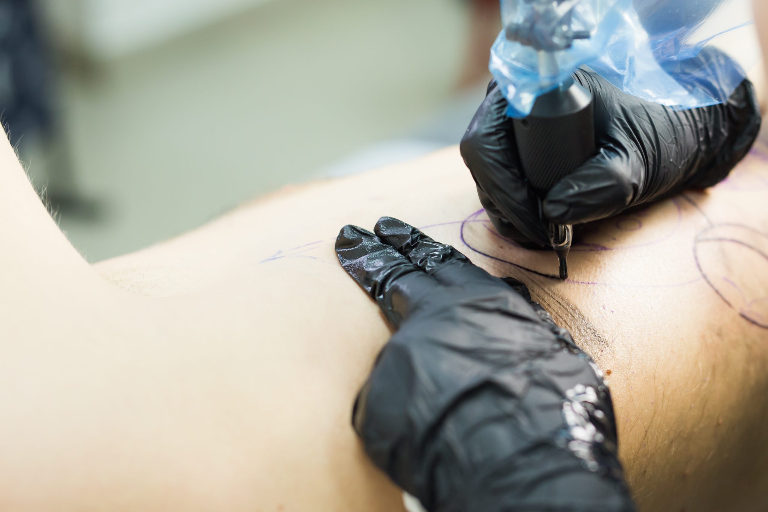 tattooer showing process of making a tattoo, hands holding a tatoo machine. tattooer showing process of making a tattoo, hands holding a tatoo machine